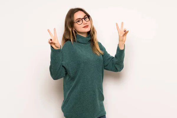 Adolescente Chica Sobre Blanco Pared Sonriendo Mostrando Signo Victoria Con —  Fotos de Stock