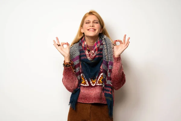 Hippie woman over white wall in zen pose