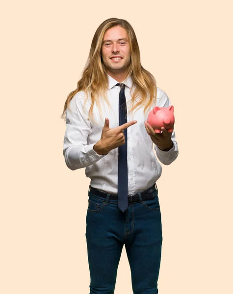 Hombre Negocios Rubio Con Pelo Largo Sosteniendo Una Alcancía Fondo —  Fotos de Stock