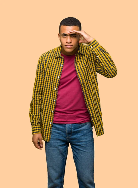 Bir şey üzerinde izole arka plan bakmak için çok uzak el ile genç afro Amerikan man arıyorum