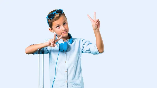 Niño Con Gafas Sol Auriculares Viajando Con Maleta Sonriendo Mostrando —  Fotos de Stock