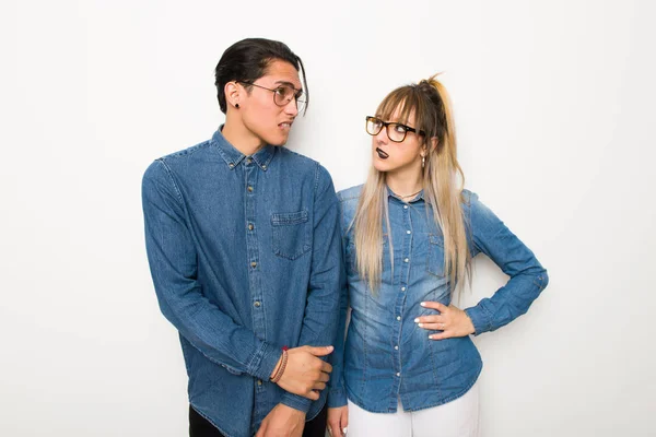Young couple with glasses with confuse face expression while bites lip