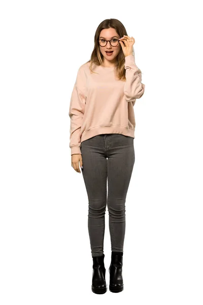 メガネと分離の白い背景にびっくりピンクのセーターとティーンエイ ジャーの女の子のフルレングス ショット — ストック写真