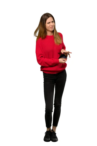 分離の白い背景の上に財布を保持する赤いセーターを持つ若い女性のフルレングス ショット — ストック写真