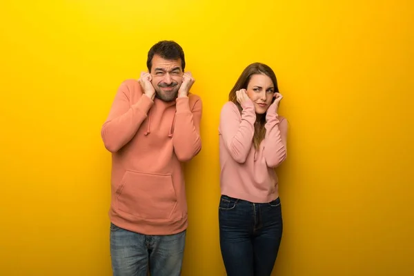 Grupo Duas Pessoas Fundo Amarelo Que Cobre Orelhas Com Mãos — Fotografia de Stock