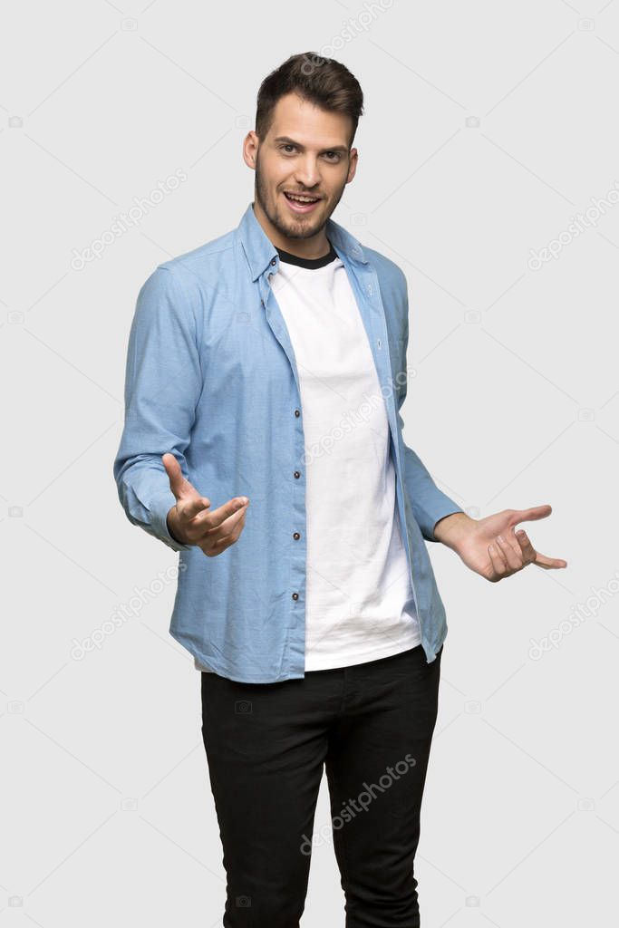 Handsome man proud and self-satisfied over grey background