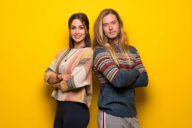 Hippi çift geçti ve ileriye dönük kollu sarı arka plan üzerinde