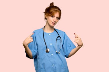 Genç redhead hemşire kibirli ve kendini beğenmiş kendini pembe arka plan üzerinde kavram seviyorum