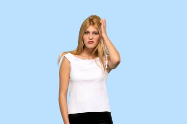 İzole mavi zemin üzerine şüpheleri sarışın genç kadın