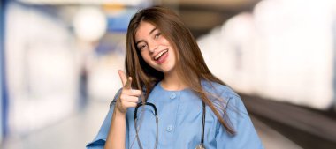 Hastanede kendine güvenen bir ifade ile size puan parmak genç hemşire