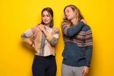 Hippi çift sarı arka plana sahip yapılmış bir çaba için omuz ağrısı muzdarip üzerinde