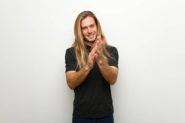 Bir konferansta sunum sonrası beyaz duvar alkış üzerinde uzun saçlı sarışın adam