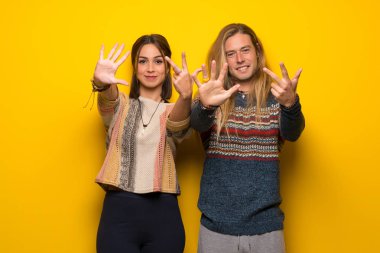 Hippi çift sekiz parmak ile sayma sarı arka plan üzerinde