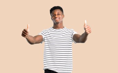 Karanlık adam ile her iki el ile jest Yaşasın vererek ve gülümseyen çizgili gömlekli derili. Neşeli ifade izole koyu sarı zemin üzerine