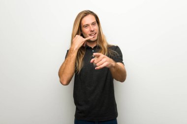 Telefon jest yapma ve açık işaret beyaz duvarın üzerinden uzun saçlı sarışın adam