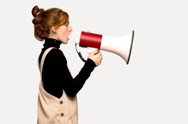 Gri arka plan üzerinde bir megafon ile bağırarak genç Kızıl saçlı kadın