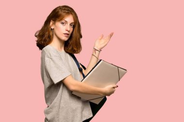 Elleri pembe arka plan üzerinde gelmek davet için tarafına uzanan genç redhead öğrenci