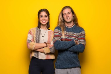 Hippi çift ön konumda geçti silah tutmak sarı arka plan üzerinde