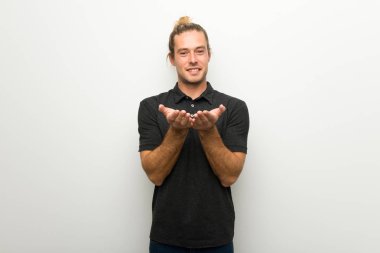 Beyaz boşaltmak hayali avuç içinde tutarak duvarın üzerinden uzun saçlı sarışın adam bir reklam eklemek için