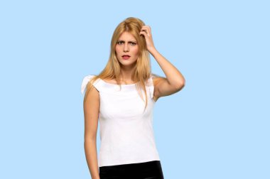 İzole mavi arka plan üzerinde kafa çizilmemesi süre şüpheleri sarışın genç kadın