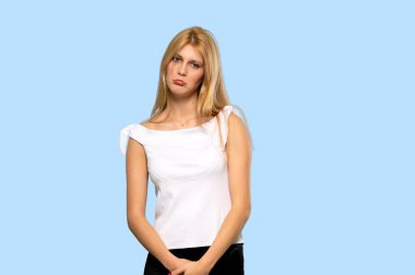Üzgün ve depresyonda ifade izole mavi arka plan üzerinde olan sarışın kadın