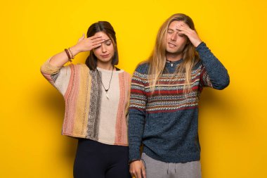 Hippi çift yorgun ve hasta ifade ile sarı arka plan üzerinde