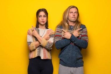 Hippi çift şüpheleri laterallerin işaret eden sarı arka plan üzerinde