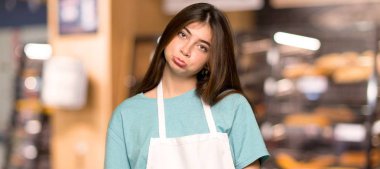 Kız üzgün ve depresyonda ifadede bir fırın ile önlük ile