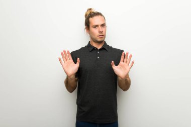 Beyaz duvar yapma dur hareketi her iki el ile üzerinden uzun saçlı sarışın adam