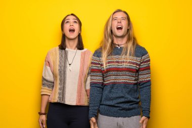 Hippi çift ağız geniş ile ön bağırarak sarı arka plan üzerinde açın