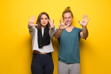 Grup sporcuların dokuz parmaklı sayma sarı arka plan üzerinde