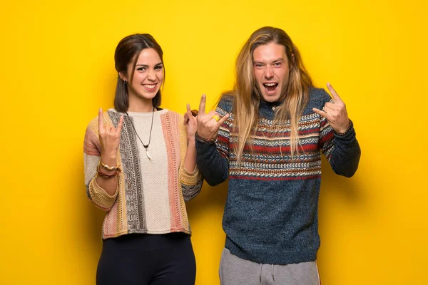 Hippie Par Över Gul Bakgrund Gör Rock Gest — Stockfoto