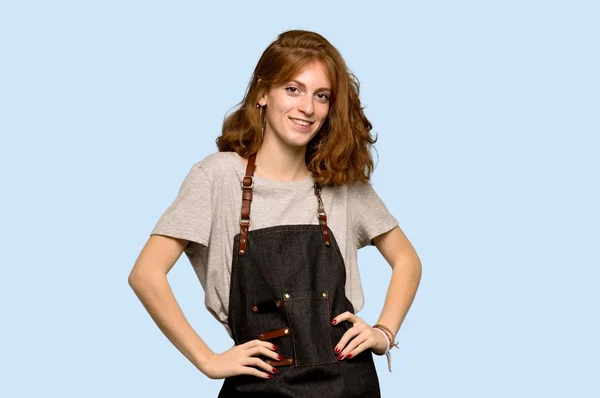Young Redhead Woman Apron Posing Arms Hip Laughing Blue Background — Stock Photo, Image