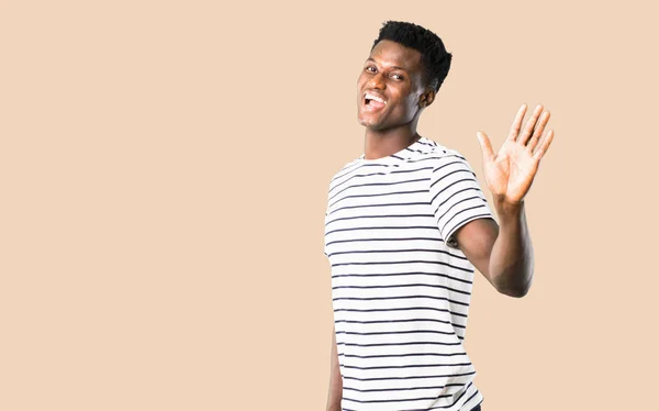 Homem Pele Escura Com Camisa Listrada Sorrindo Saudando Fundo Ocre — Fotografia de Stock