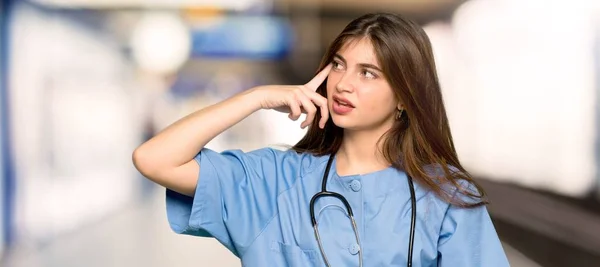 Jovem Enfermeira Fazendo Gesto Loucura Colocando Dedo Cabeça Hospital — Fotografia de Stock