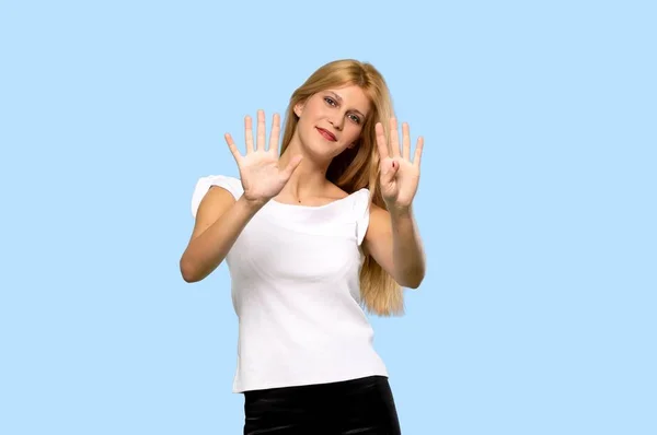 Молодая Блондинка Насчитавшая Девять Пальцев Изолированном Синем Фоне — стоковое фото