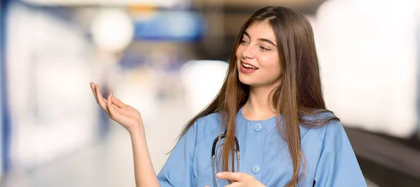 Jonge Verpleegster Uitbreiding Van Handen Aan Zijkant Voor Het Uitnodigen — Stockfoto