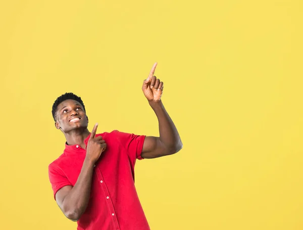 Young african american man pointing with the index finger a great idea and looking up on yellow background