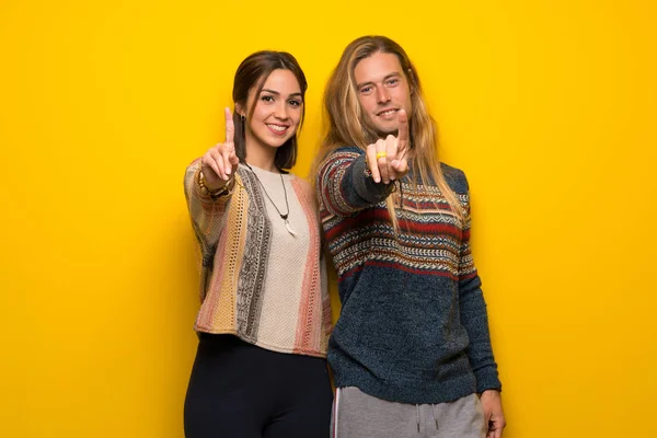 Hippie Casal Sobre Fundo Amarelo Mostrando Levantando Dedo — Fotografia de Stock