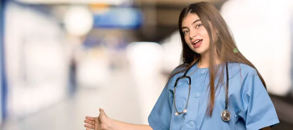 Jovem Enfermeira Apontando Para Trás Apresentando Produto Hospital — Fotografia de Stock