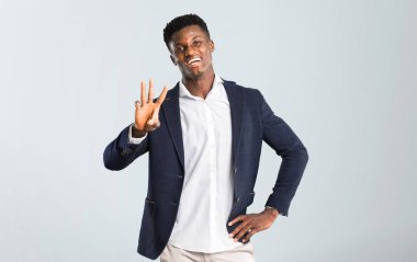 Mutlu bir ceket ve üç ile izole gri arka plan üzerinde parmak sayma Afro-Amerikan yakışıklı