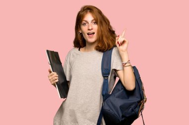 Parmak pembe arka plan üzerinde kaldırma sırasında çözüm isteyen genç redhead öğrenci anlar