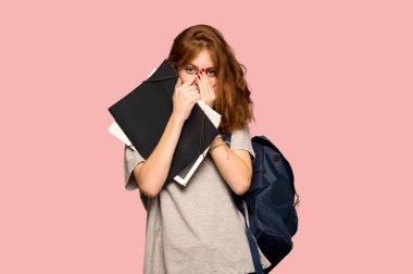 Çok pembe arka plan üzerinde ağız kapsayan süre gülümseyen genç redhead öğrenci