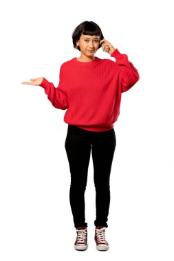 Kırmızı kazaklı parmak izole beyaz arka plan üzerinde kafasına koyarak delilik jesti yapmak kısa saçlı kızla tam uzunlukta bir kadeh