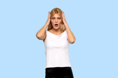 Sarışın genç kadın şaşırttı ve hemen aramaya mavi arka plan izole iken şok