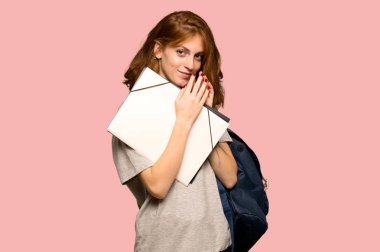 Pembe arka plan üzerinde bir şey entrikacı genç redhead öğrenci