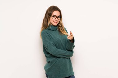 Genç kız beyaz duvar üzerinde parmak seni kendinden emin bir ifadesiyle işaret