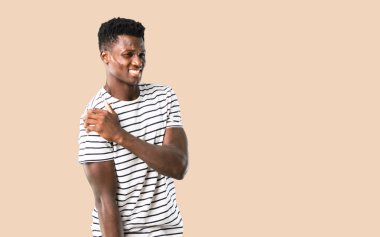 Çizgili gömlekli ile omuz ağrısı izole koyu sarı zemin üzerine koyu tenli adam