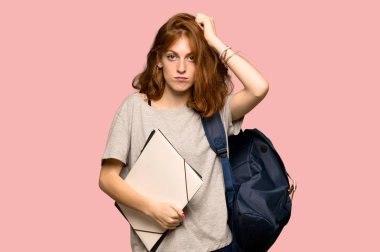 Hayal kırıklığı ve pembe arka plan üzerinde anlayış değil bir ifade ile genç redhead öğrenci