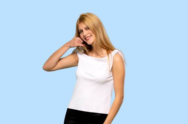 Sarışın genç kadın telefon jest yapma. Bana arka işaret izole mavi arka plan üzerinde de